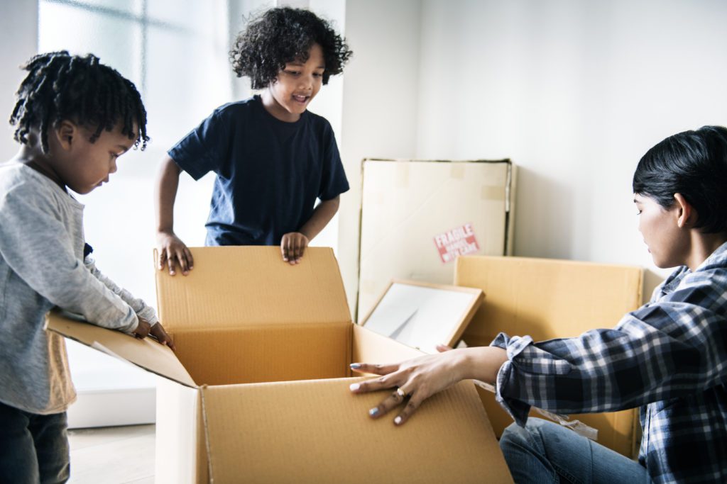 Mother and children with moving boxes - Make piles of what to toss, sell, or donate