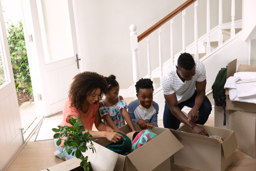 Sell the valuable stuff and toss the rest - Couple with her son and daughter at home, unpacking boxes, lifestyle