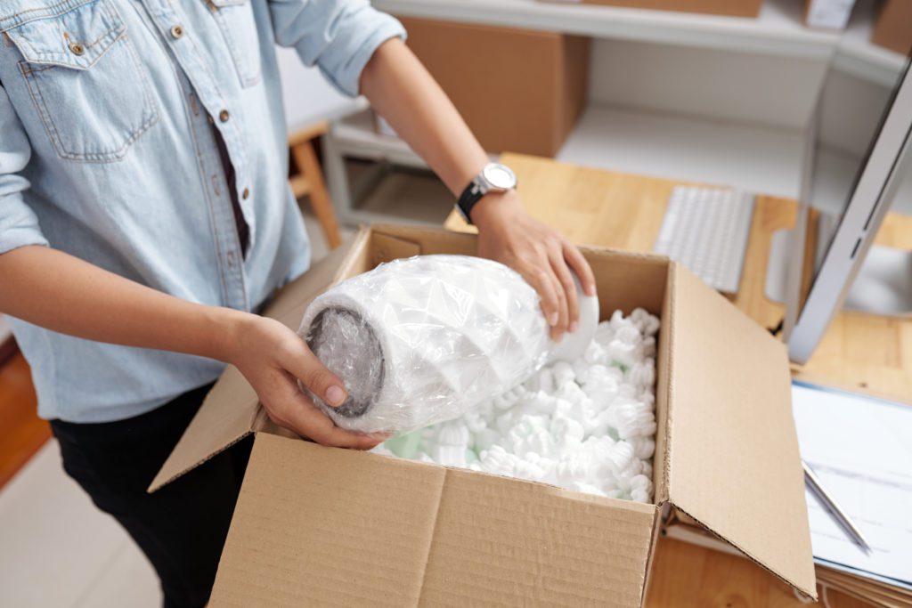 Pack in advance of moving day - woman packing a vase
