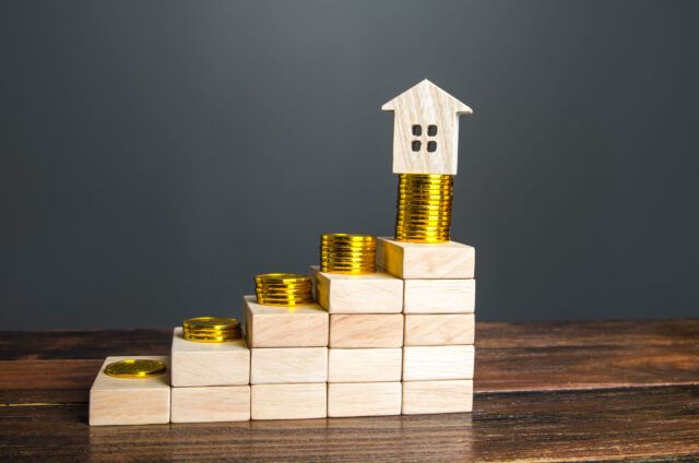 Steps with increasing profits and a house on top. Saving money to buy a house. High mortgage rates. Loan approval, payment system. Real estate investment. Profitability assessment. Property valuation.