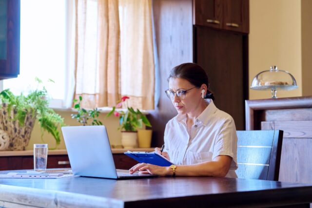 a woman working on her laptop, trying to market her home online