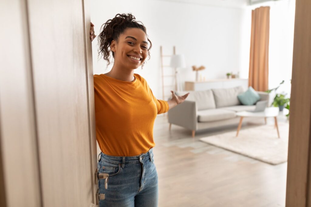 a young female welcoming guests to her rented home